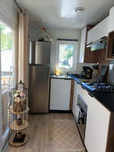雷日卡普费雷mobil-home neuf 4-6 places camping Siblu les viviers的厨房配有不锈钢冰箱和台面
