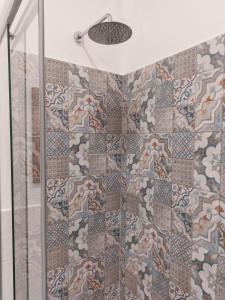 萨沃纳Appartamento Piazzetta La Maddalena的玻璃门淋浴和马赛克瓷砖墙