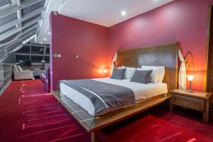 萨拉热窝阿斯特拉酒店的一间卧室设有一张床和红色的墙壁