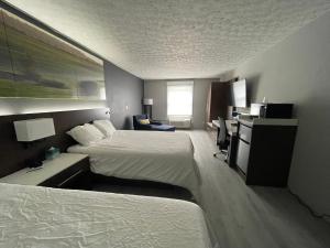 埃尔金斯Luxor Inn & Suites, a Travelodge by Wyndham的酒店客房配有两张床和一张书桌