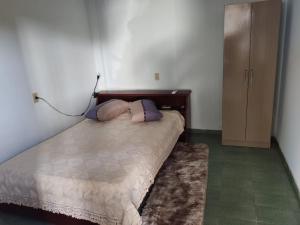 伊瓜苏Quarto aconchegante na terra das cataratas的一间卧室配有一张带两个枕头的床