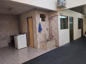 伊瓜苏Quarto aconchegante na terra das cataratas的客房设有带冰箱的瓷砖墙