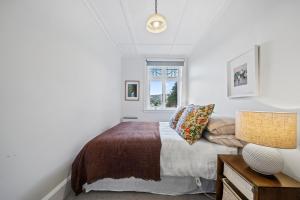 惠灵顿Capital Charm - Wellington Holiday Unit的一间卧室设有一张床和一个窗口