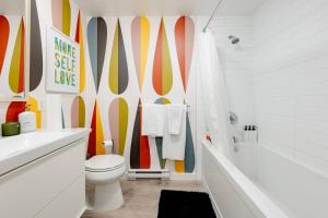 温哥华Hidden Gem: Historical Gastown的浴室设有卫生间,墙上设有冲浪板。