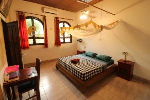 坎古Serenity Eco Guesthouse - CHSE certified的卧室配有床、桌子和窗户。