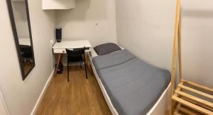 库里提巴Gup Hostel的小房间设有一张床和一张书桌