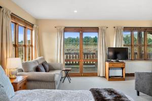 国家公园Mountain Heights Lodge的客厅配有电视、沙发和电视。