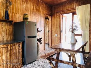 邦美蜀DuGiang Homestay的厨房配有冰箱和木桌