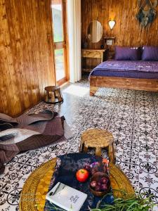 邦美蜀DuGiang Homestay的一间房间,配有一张床和一张桌子,上面有水果