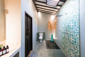 吉利特拉旺安椰子花园度假酒店的浴室配有卫生间和蓝白色墙壁。