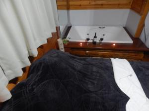 Núcleo MauáChalé Silvia Gatto - Suíte Bauru的带浴缸的客房内的一张床位