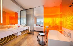 上海上海外滩W酒店的橙色浴室设有浴缸和水槽