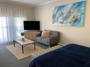 杰林冈Mountain Views (3 min drive to beach)的客厅配有床、沙发和电视。