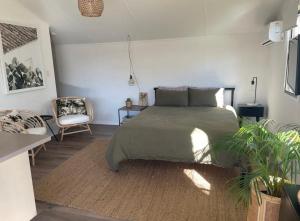 卡巴雷塔海滩Caba Beach Cabin的一间卧室配有一张大床和一把椅子