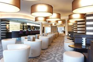 卢森堡阿尔维斯帕克酒店的一间设有白色椅子和桌子及灯的餐厅