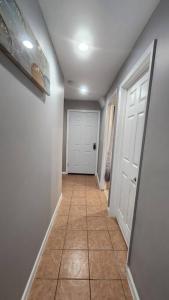 纽瓦克Cozy King Bed, Free Parking!的走廊设有瓷砖地板和白色门