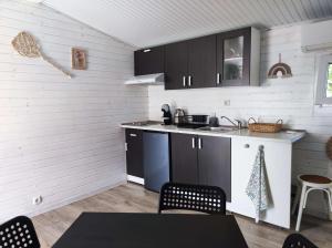 辛尼莫雷特Къщички Морски Светулки的厨房配有黑色橱柜和桌椅