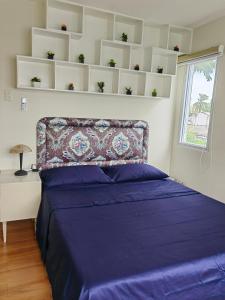 达沃市Casa Felicitas 1的一间卧室配有一张带紫色床单的床和窗户。
