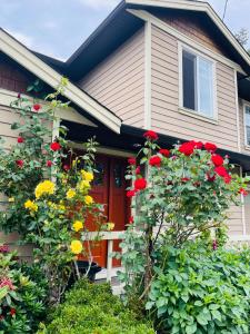 维多利亚Garden home in Victoria -Beautiful home in Victoria的一座房子,有红色的门和一些花