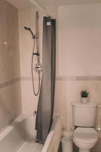 牛津Spacious 2 bedroom apartment in Central Oxford的浴室设有卫生间和带浴帘的淋浴。
