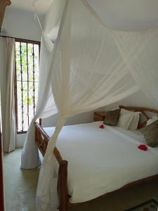 迪亚尼海滩Sonrisa Villas的一间卧室配有一张带天蓬的白色床