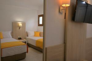 欧拉努波利斯Aristoteles Holiday Hotel And Spa的酒店客房设有两张床和电视。