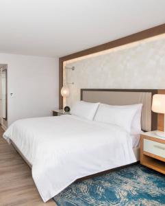 纽波特海滩纽波特海滩文艺复兴酒店的卧室配有一张白色大床和蓝色地毯。
