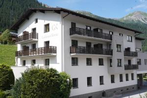 圣安东阿尔贝格Quality Hosts Arlberg - Hotel Goldenes Kreuz B&B的一座大型白色建筑,设有阳台