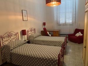 彼得拉桑塔Casa Pucci的一间卧室配有两张床、一把椅子和一个吊灯。
