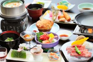 Komaba湯元ホテル阿智川的餐桌,盘子上放着食物和碗