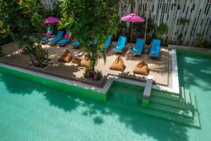 奥南海滩Areetara Aonang Krabi的一组椅子和遮阳伞,位于游泳池旁