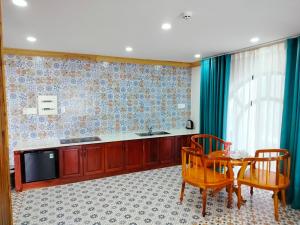 潘郎Phuc Thuan Hotel的一间带桌椅的厨房和一台电视