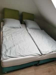 格奥尔格斯马林许特Ferienwohnung 308 am Kasinopark 2 Zimmer的一张带白色床单和枕头的未铺好的床