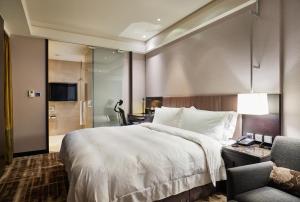 台北天阁酒店台北南西的酒店客房带一张大床和一把椅子