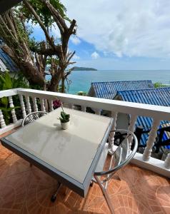 芭东海滩Sunset Seaview Patong的阳台上配有白色的桌椅,享有海景