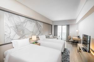上海长河国际公寓新天地的酒店客房设有两张床,墙上挂有绘画作品