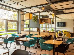 多特蒙德多特蒙德市宜必思酒店的餐厅设有桌椅和窗户。