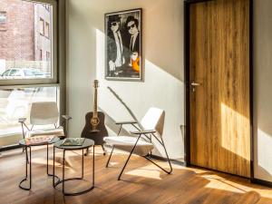 多特蒙德多特蒙德市宜必思酒店的一个带椅子、吉他和门的房间