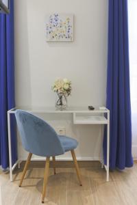 阿利坎特Dorinda Rooms的一张带蓝色椅子的桌子,位于一间蓝色窗帘的房间