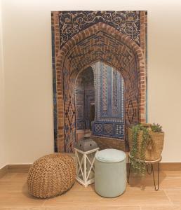 阿利坎特Dorinda Rooms的一间设有摩洛哥门廊的房间,配有一张桌子和一张凳子