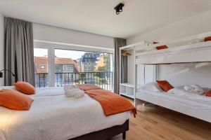 科克赛德Strandparel luxueus duplex appartement met 2 terrassen én parking的一间卧室设有两张床和大窗户