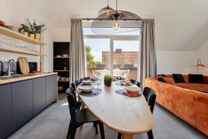 科克赛德Strandparel luxueus duplex appartement met 2 terrassen én parking的厨房以及带桌子和沙发的客厅。