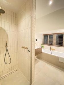吕伐登Parkzicht的带淋浴、盥洗盆和浴缸的浴室