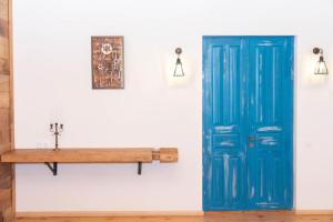 SazanoEthno Sazano Hotel的蓝色的门和墙上的木凳