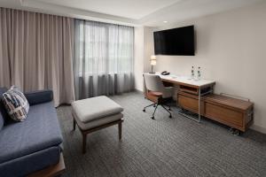 贝尔维尤西雅图贝尔维尤/市中心万怡酒店的酒店客房配有书桌、沙发和椅子。