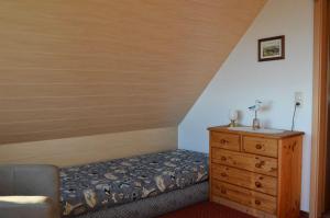 萨斯尼茨Ferienhaus Wagner的一间卧室配有一张床和一个木制梳妆台