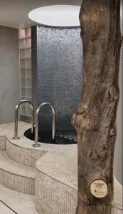 伦敦Bitcoin Adorabile suite nel cuore del magnifico Chiswick的浴室设有三个水槽和树干