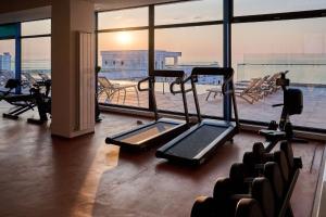 马马亚Infinity Breezes Apartment Beach Resort - parking的健身房设有有氧器材和大窗户