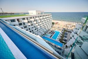 马马亚Infinity Breezes Apartment Beach Resort - parking的毗邻大海的带游泳池的酒店