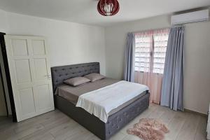 帕拉马里博Paradijs in Paramaribo的一间卧室设有一张大床和一个窗户。